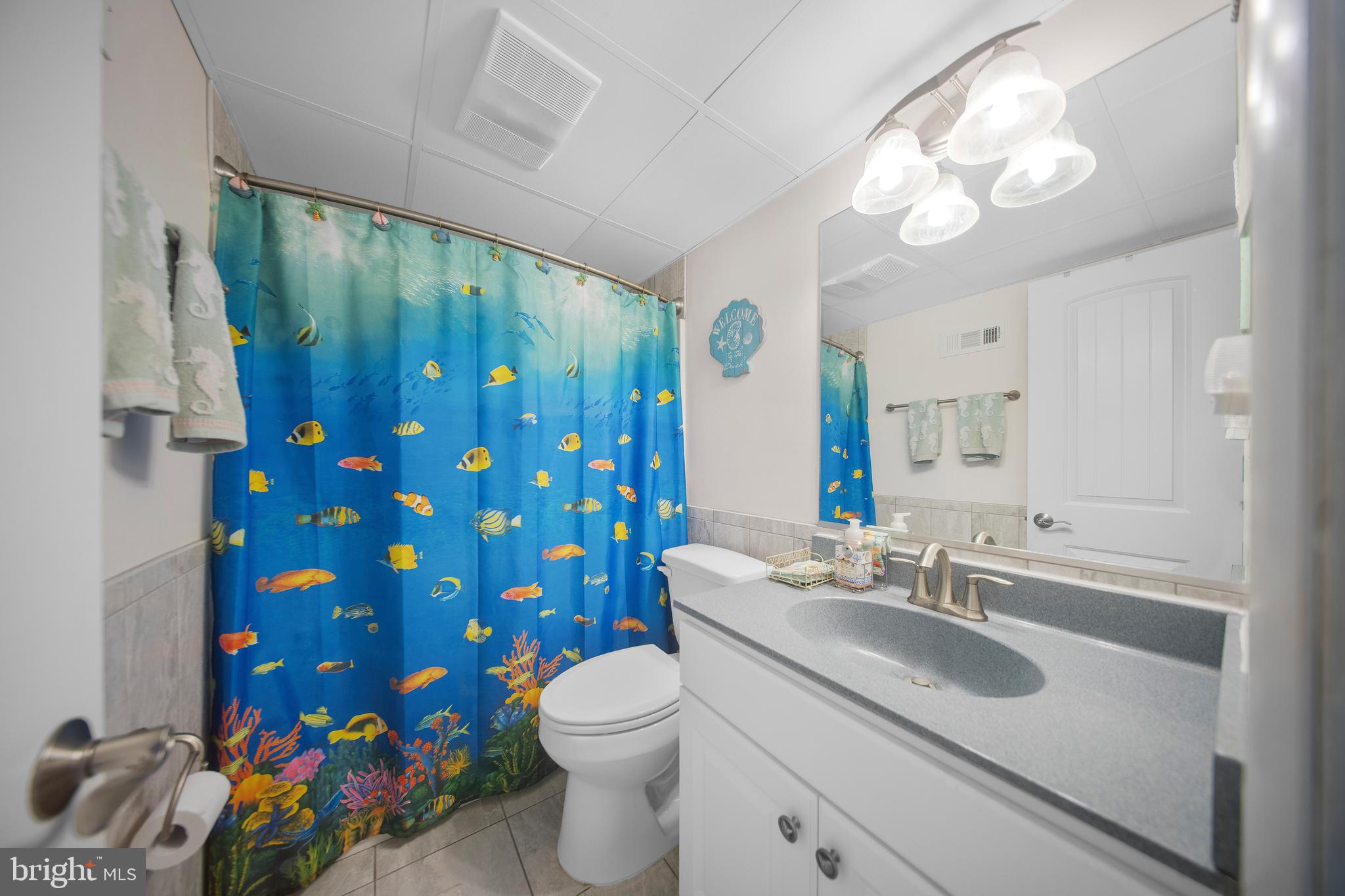 5505 Atlantic Avenue, Unit 107 Ocean City, MD 21842 - Photo 22 of 25 a bathroom with a sink a toilet and shower curtain
