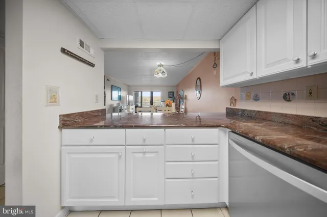 a kitchen with granite countertop white cabinets and a sink