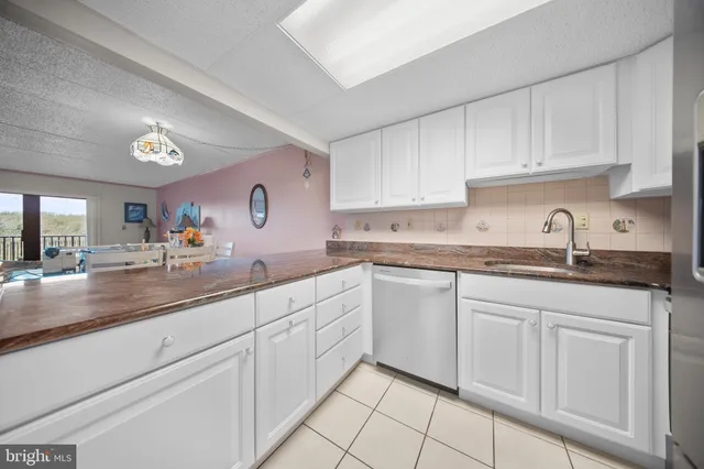a kitchen with white cabinets and sink