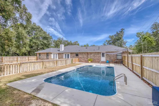 a view of a house with backyard and sitting area