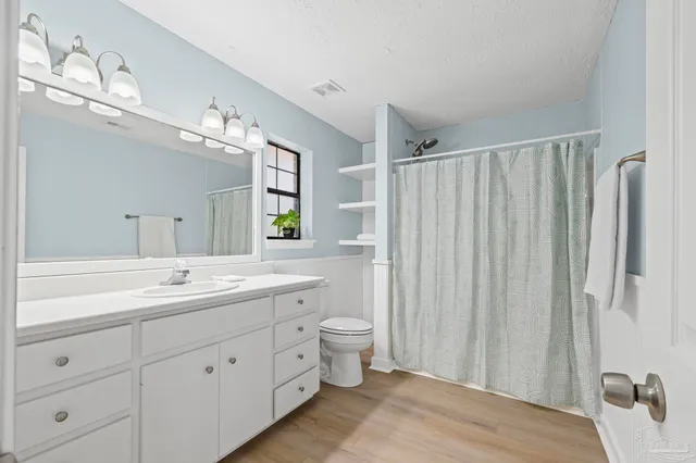 a en suite bathroom with a granite countertop sink and a mirror
