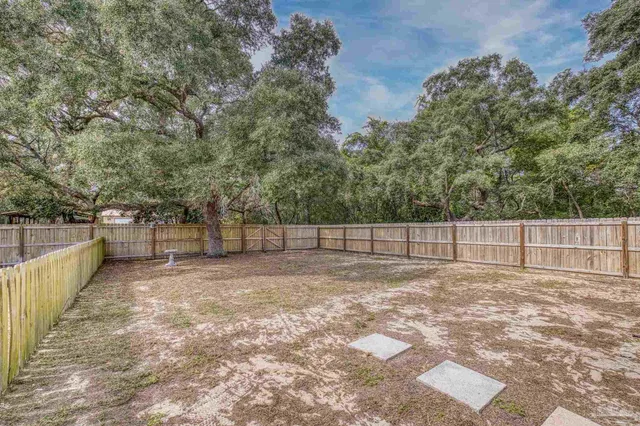 a view of a house with backyard and tree