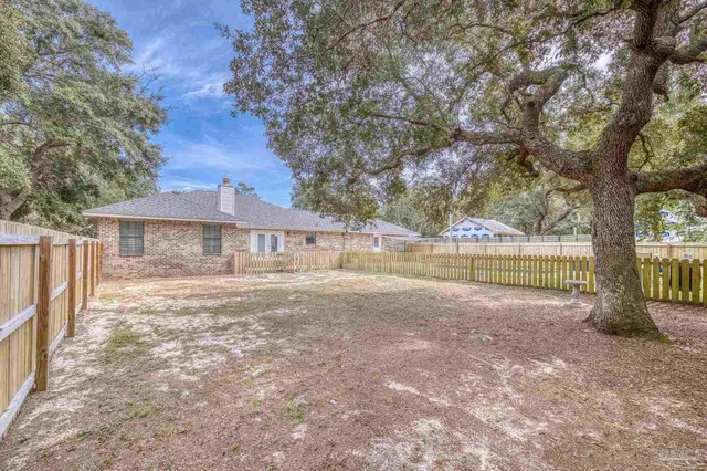 a view of a balcony with floor to ceiling windows and a wooden fence