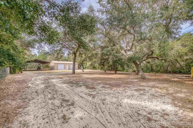 a front view of a house with a yard and potted plants