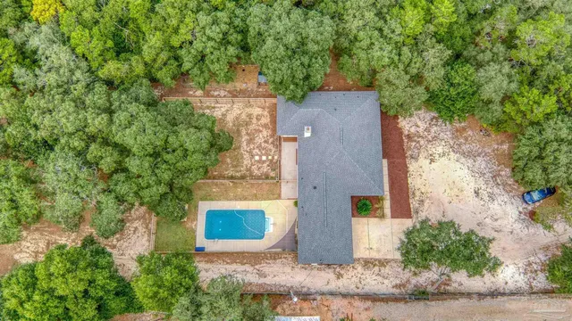 an aerial view of a house with a yard and a large tree