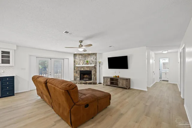 a living room with furniture a flat screen tv and a fireplace