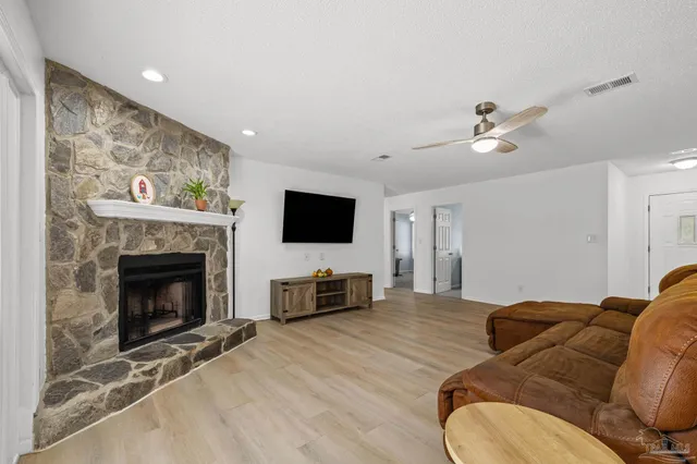 a living room with furniture a flat screen tv and a fireplace