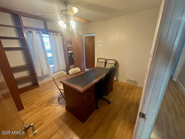a living room with a table chairs and wooden floor