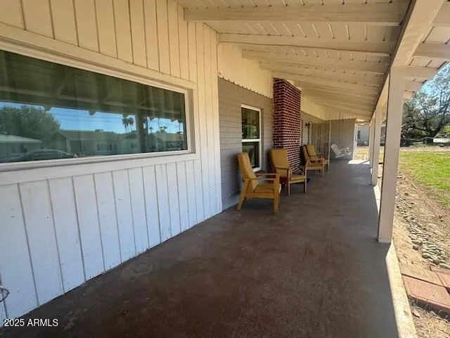 a view of a porch with furniture and floor to ceiling window
