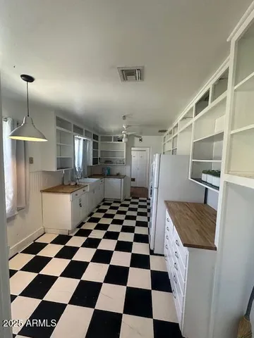 a kitchen with a checkered floor and white cabinets