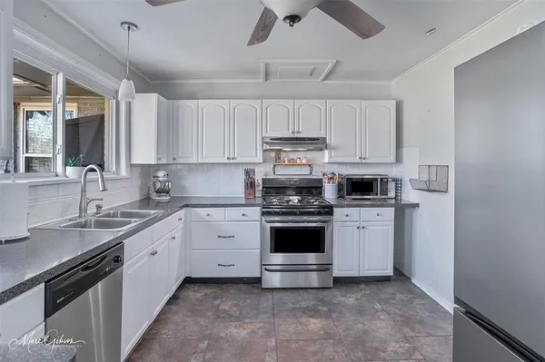 a kitchen with stainless steel appliances granite countertop a sink and cabinets