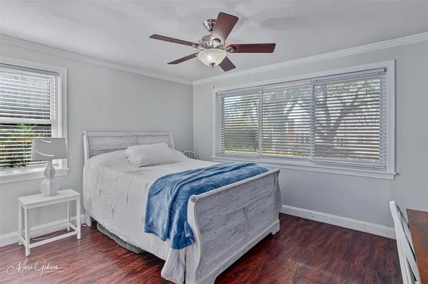 a bedroom with a large bed chandelier and a window