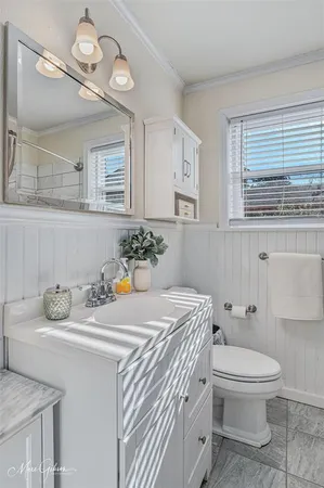 a bathroom with a sink a toilet and a mirror