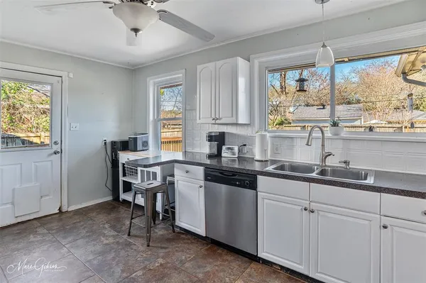 a kitchen with a sink window and cabinets