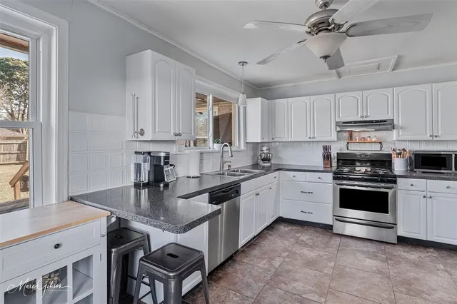 a kitchen with stainless steel appliances granite countertop a lot of counter space and a sink