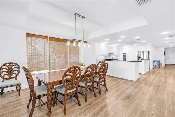 a view of a dining room and livingroom with furniture wooden floor a rug a chandelier
