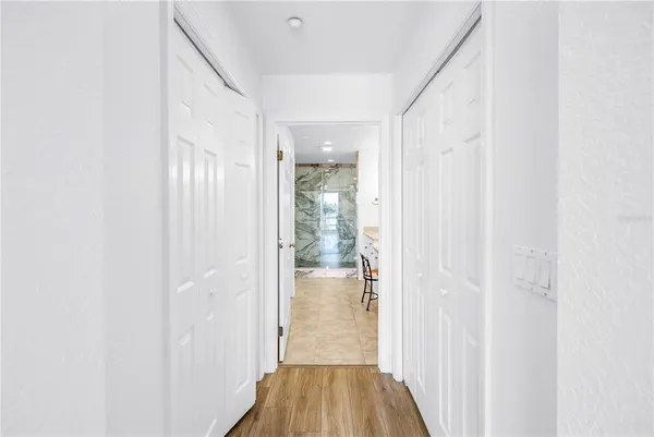 a view of a hallway with wooden floor and staircase