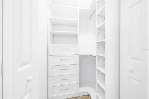 a view of walk in closet with empty racks