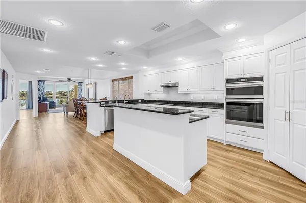 a kitchen with stainless steel appliances kitchen island granite countertop a stove and a refrigerator