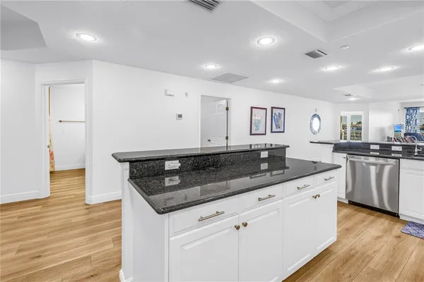 a kitchen with granite countertop a sink and white cabinets