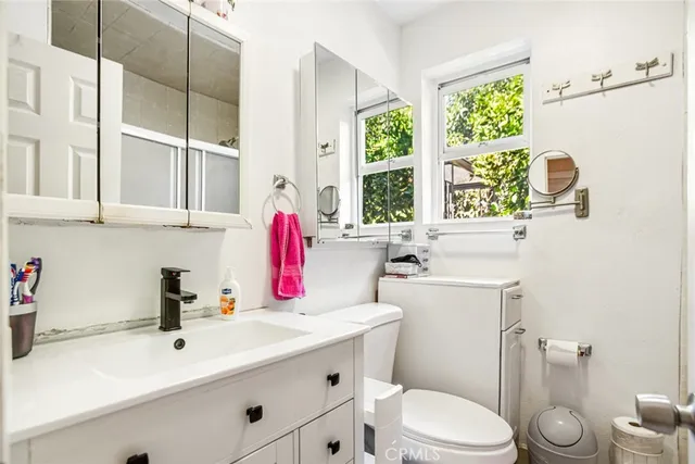 a bathroom with a sink toilet vanity and window