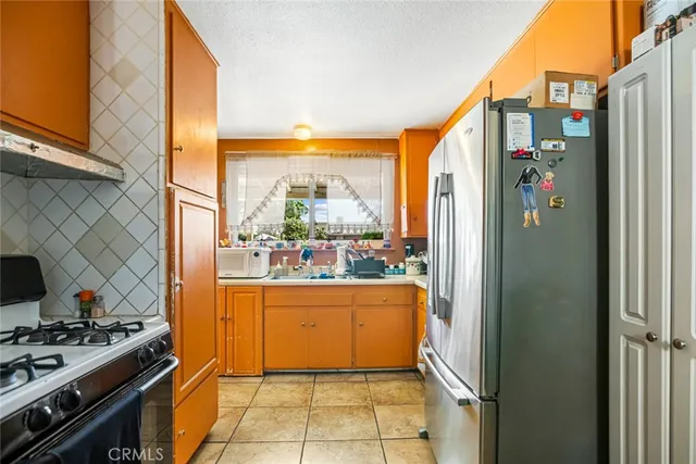 a kitchen with stainless steel appliances granite countertop a refrigerator and a stove