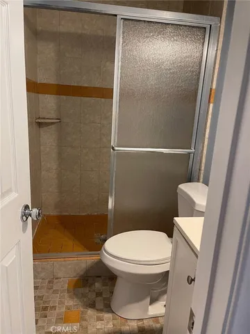 a white toilet sitting next to a shower