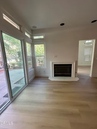 a view of an empty room with a fireplace and a window