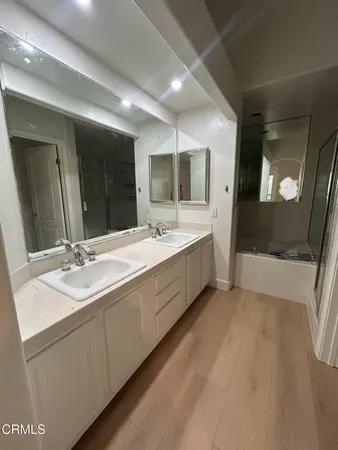 a spacious bathroom with a double vanity sink and a mirror