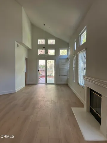 a view of an empty room with a fireplace and a window