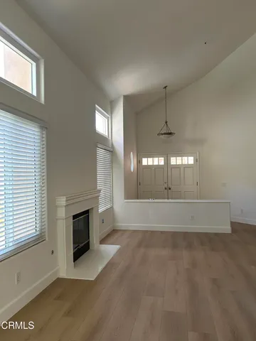 a view of empty room with wooden floor and fireplace