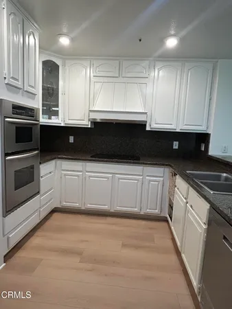 a kitchen with stainless steel appliances kitchen island granite countertop a sink and cabinets
