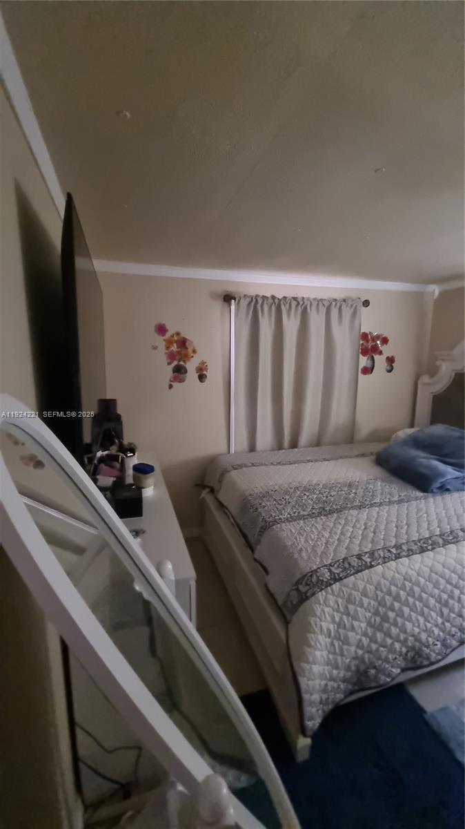 3170 Southwest 8th Street Miami, FL 33135 - Photo 22 of 33 a bedroom with a bed and a flat tv screen on a dresser