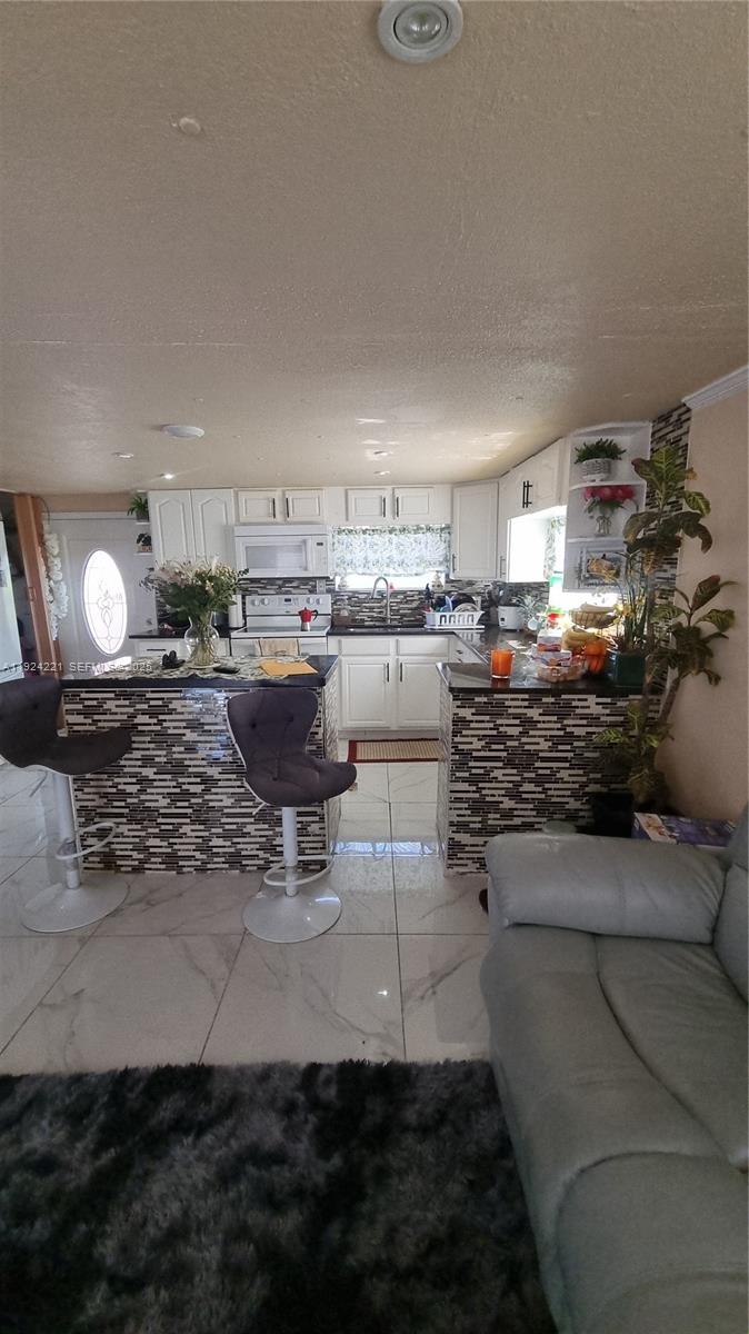 3170 Southwest 8th Street Miami, FL 33135 - Photo 4 of 33 a kitchen with a stove a sink and a counter top space