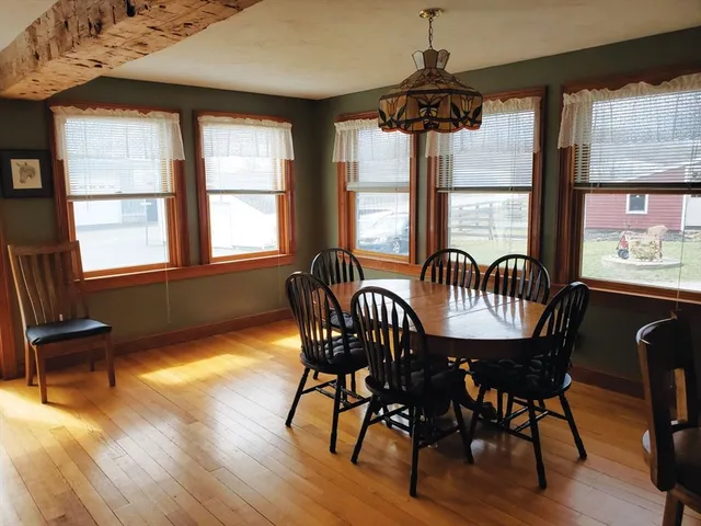 a dining room with furniture a chandelier and wooden floor