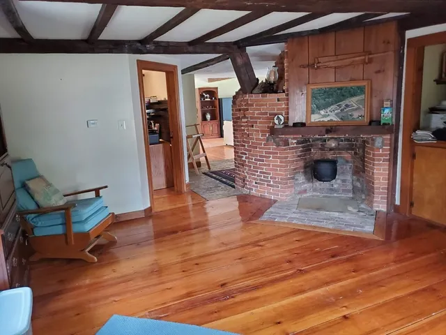 a living room with wooden floor and a fireplace