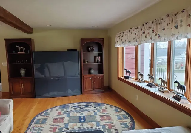 a living room with chairs and a rug