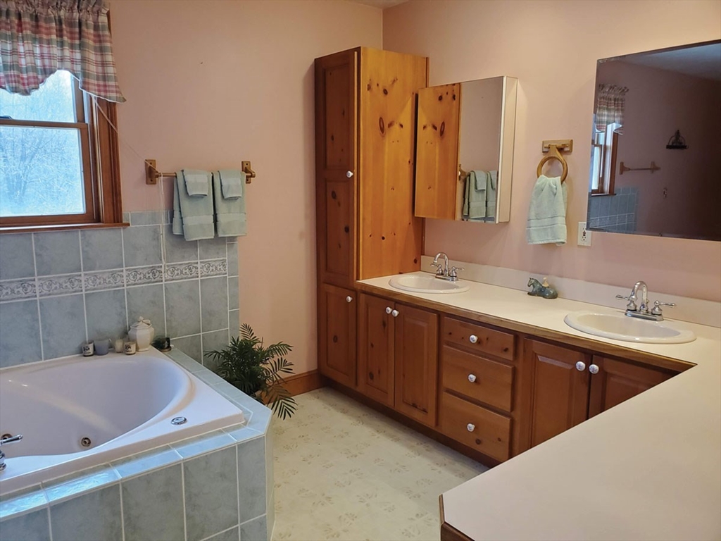 64 Arch Street Westborough, MA 01581 - Photo 19 of 42 a bathroom with a tub sink and mirror