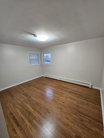 a view of room with wooden floor and windows