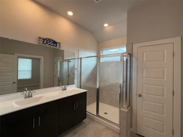 a bathroom with a double vanity sink mirror and shower