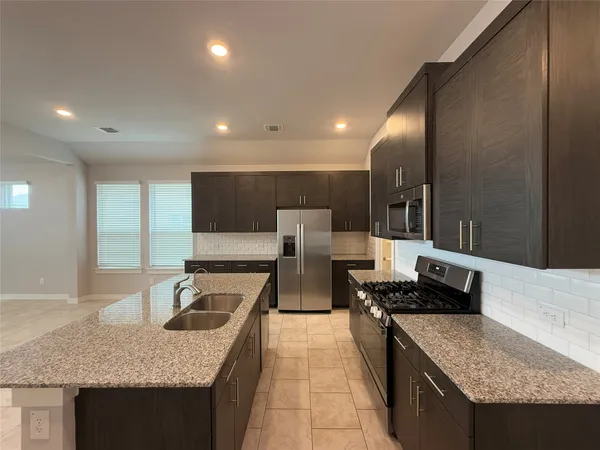 a kitchen with stainless steel appliances granite countertop a sink and a stove