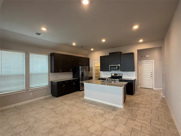 a kitchen with stainless steel appliances a refrigerator and a stove top oven