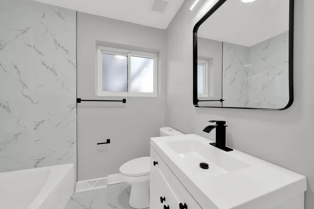 a bathroom with a toilet sink and mirror