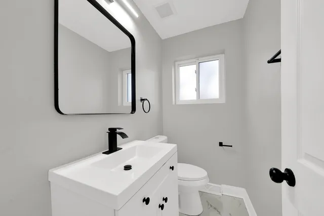 a bathroom with a toilet sink and mirror