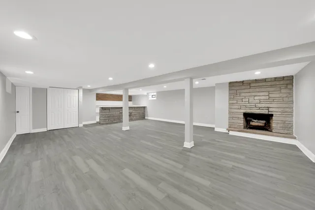 an empty room with wooden floor and fireplace