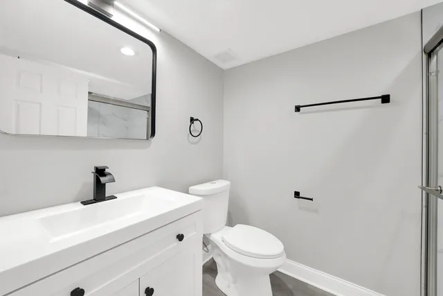 a bathroom with a sink a toilet and a shower