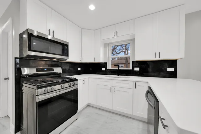 a kitchen with stainless steel appliances granite countertop a stove a microwave and cabinets