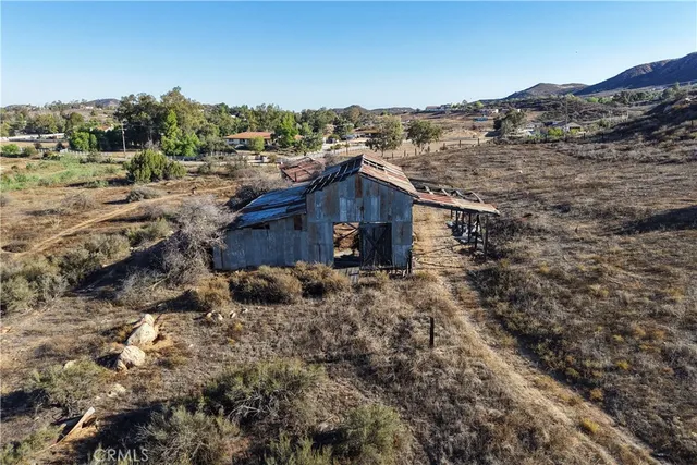 a view of a house with a yard and large trees
