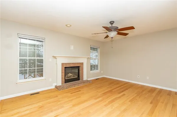 a view of empty room with a fireplace and fan