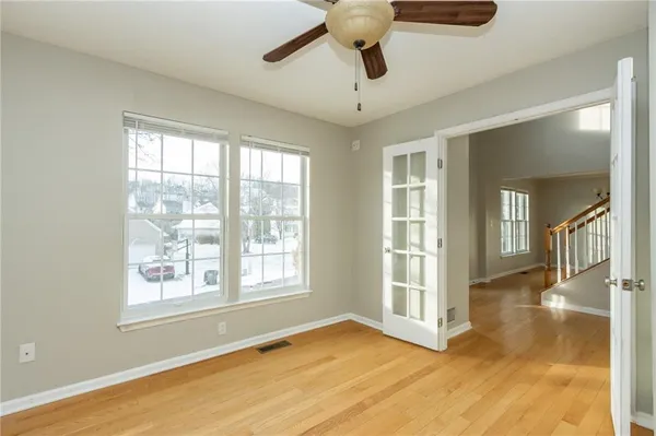 a view of an empty room with a window and wooden floor